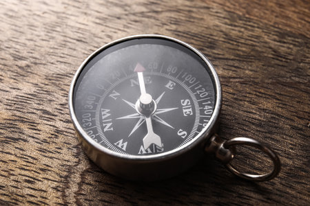 Retro compass on dark wooden background, closeup