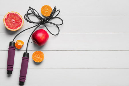 Skipping rope and fresh fruits on white wooden backgroundの写真素材