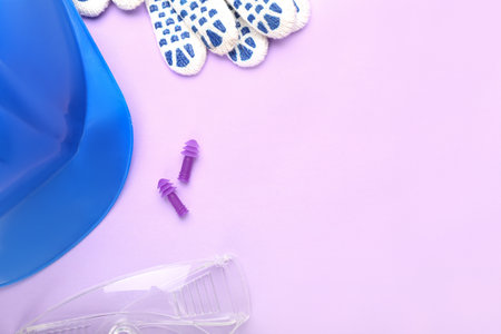 Earplugs, hardhat, safety goggles and gloves on color backgroundの写真素材