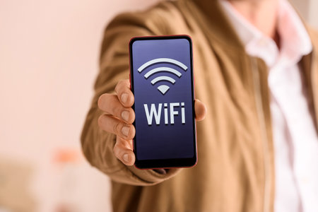 Man showing mobile phone with WiFi symbol, closeupの写真素材