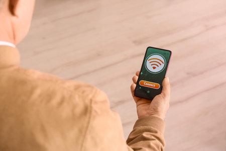 Man holding mobile phone with WiFi symbol and connection button on light background