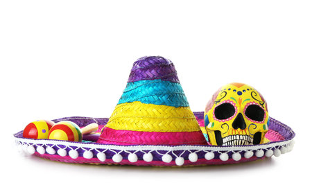 Painted human skull for Mexico's Day of the Dead (El Dia de Muertos), maracas and sombrero on white backgroundの写真素材