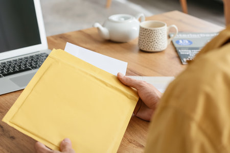 Young man with letter at home, closeup