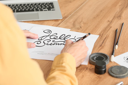 Young male calligrapher working at home, closeupの写真素材