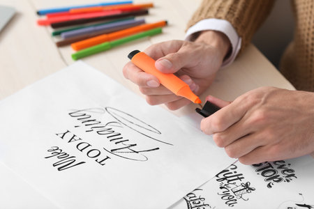 Young male calligrapher working in office, closeupの写真素材