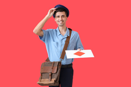 Handsome young postman with letter on color backgroundの写真素材