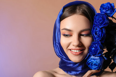 Stylish young woman with blue roses on color backgroundの写真素材