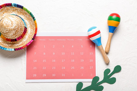 Mexican maracas, calendar with marked date 5 May (Cinco de Mayo) and sombrero on white backgroundの写真素材
