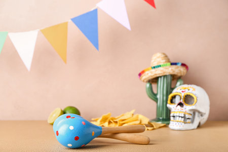 Painted human skull for Mexico's Day of the Dead (El Dia de Muertos), maracas, cactus, nachos and...