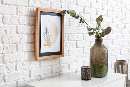 Vase with candle on shelf near brick wall