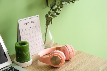 Modern workplace with headphones near color wallの写真素材