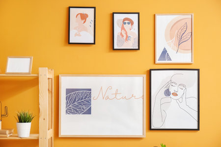 Stylish pictures hanging on color wallの写真素材