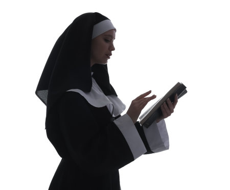 Silhouette of young nun with Bible on white backgroundの写真素材