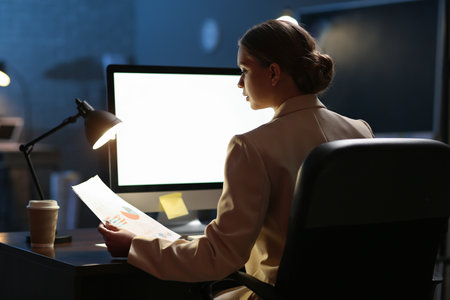 Young woman working on computer in office late at nightの写真素材