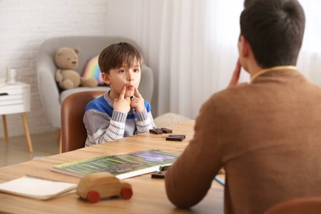 Cute little boy training pronounce letters at speech therapist officeの写真素材