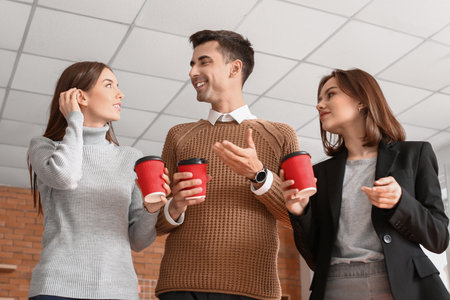 Business colleagues drinking coffee in officeの写真素材
