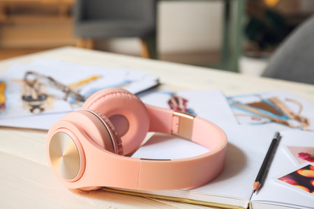 Headphones with notebook on table in roomの写真素材