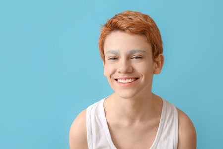 Teenage boy with dyed eyebrows on color backgroundの写真素材