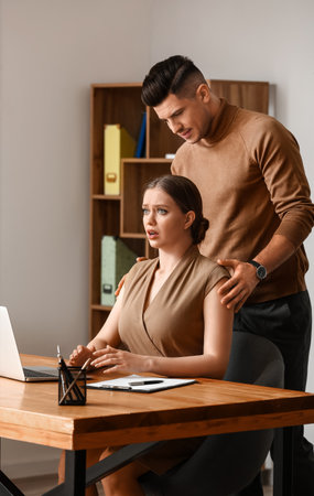 Boss harassing his secretary in officeの写真素材