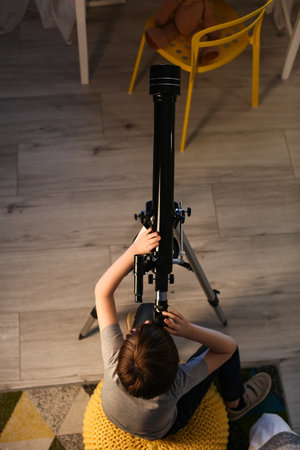 Little boy looking at stars through telescope in evening, top viewの写真素材