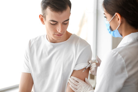 Doctor vaccinating patient against covid-19 in clinic
