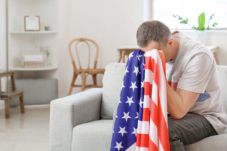 Sad man with USA flag at home. memorial day celebrationの写真素材