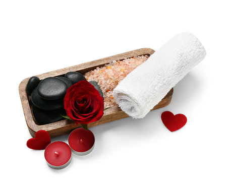 Beautiful spa composition for Valentine's Day with rose, towel, sea salt, candles and stones on white backgroundの写真素材