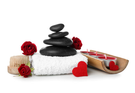 Beautiful spa composition for Valentine's Day with flowers, candles, towel and stones on white backgroundの写真素材