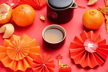 Teapot with cup, mandarins and Chinese symbols on red background, closeup. new year celebrationの写真素材