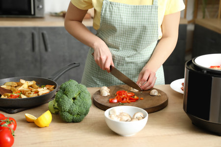 woman cutting mushroom in kitchenの写真素材