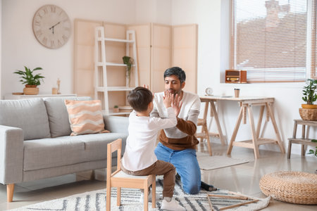 Happy father and his little son at homeの写真素材