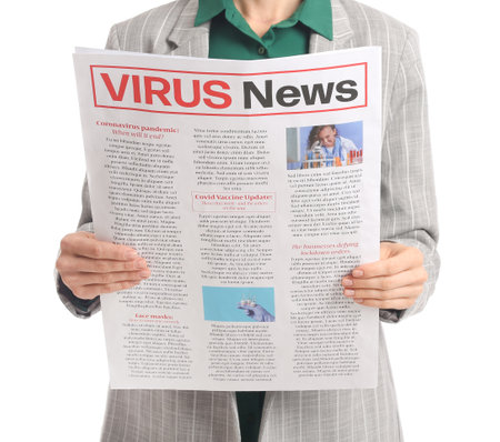 Young businesswoman reading newspaper on white backgroundの写真素材