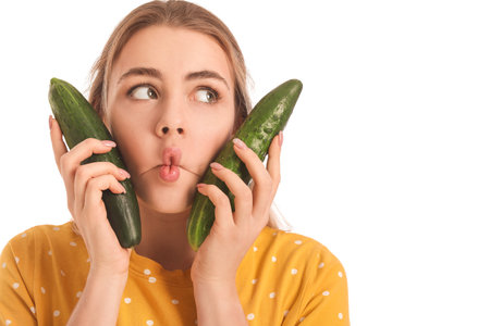 Young woman with cucumber on white backgroundの写真素材