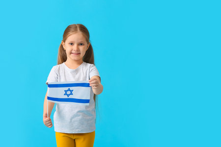 Little girl with the flag of Israel on color backgroundの写真素材