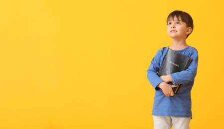 Little boy with Bible on color backgroundの写真素材