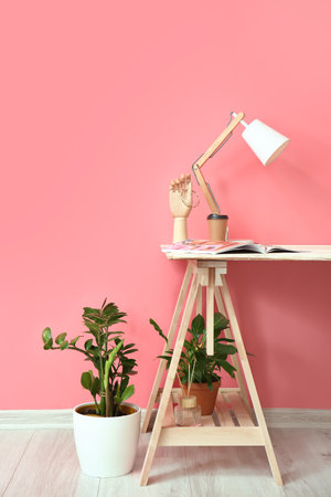 Modern workplace with lamp near color wallの写真素材