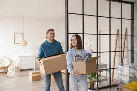 Young couple with cardboard boxes in their new house on moving day