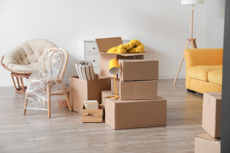 Cardboard boxes with accessories in room on moving day