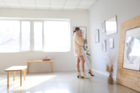 Women at exhibition in modern art gallery, blurred viewの写真素材