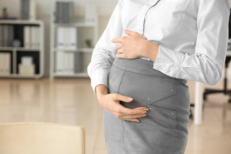 Pregnant businesswoman working in officeの写真素材