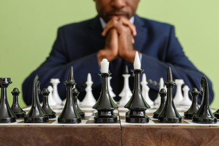 African-American man playing chess at table