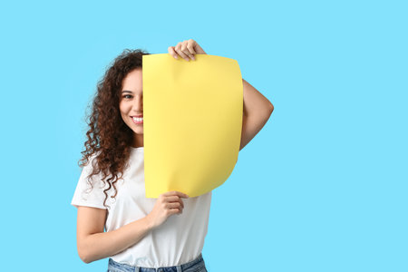 Young woman with blank paper sheet on color backgroundの写真素材