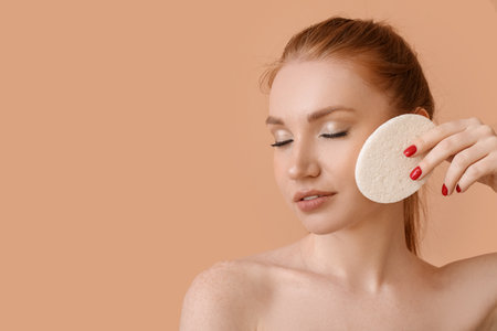 Beautiful woman with makeup sponge on color backgroundの写真素材