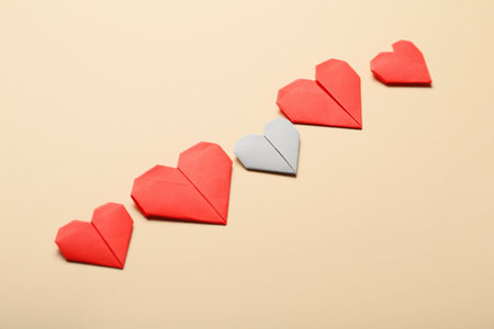 Origami hearts on color background. concept of uniqueness