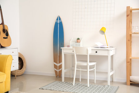 Interior of modern stylish room with surfboard and table with chairの写真素材