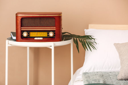 Retro radio receiver on table in bedroomの写真素材