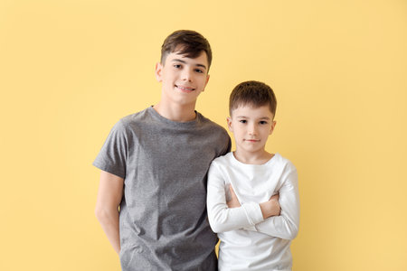 Portrait of cute brothers on color backgroundの写真素材
