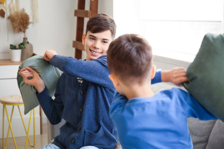Naughty brothers fighting pillows at home