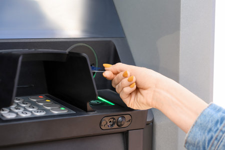 Woman withdrawing money from ATM, closeupの写真素材