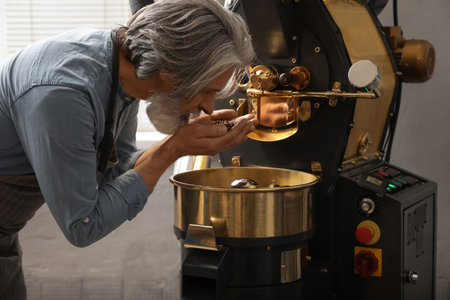 Senior man using modern coffee roaster